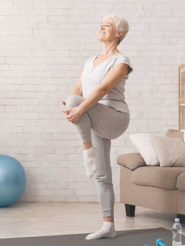 Active senior woman doing legs exercise at home